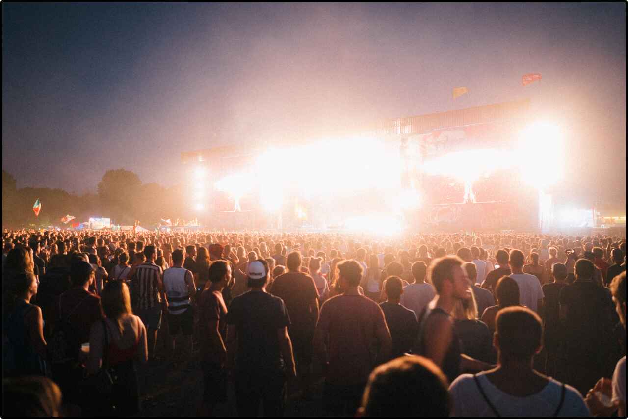 Crowded music festival venue with spectators enjoying performances from afar